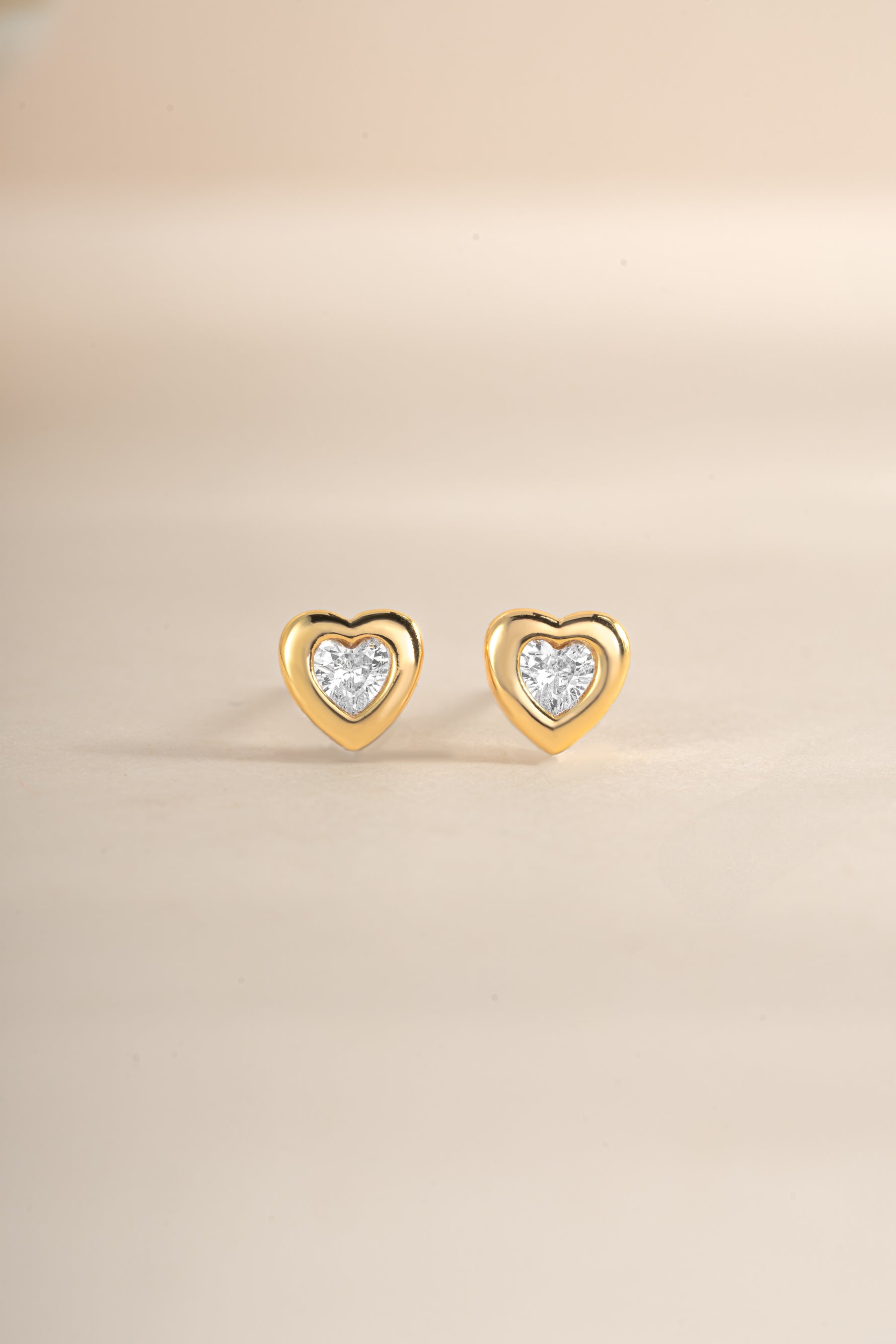 Gold bezel heart stud earrings by Sami Jewels, front view showing delicate heart-shaped design and secure stud backing.
