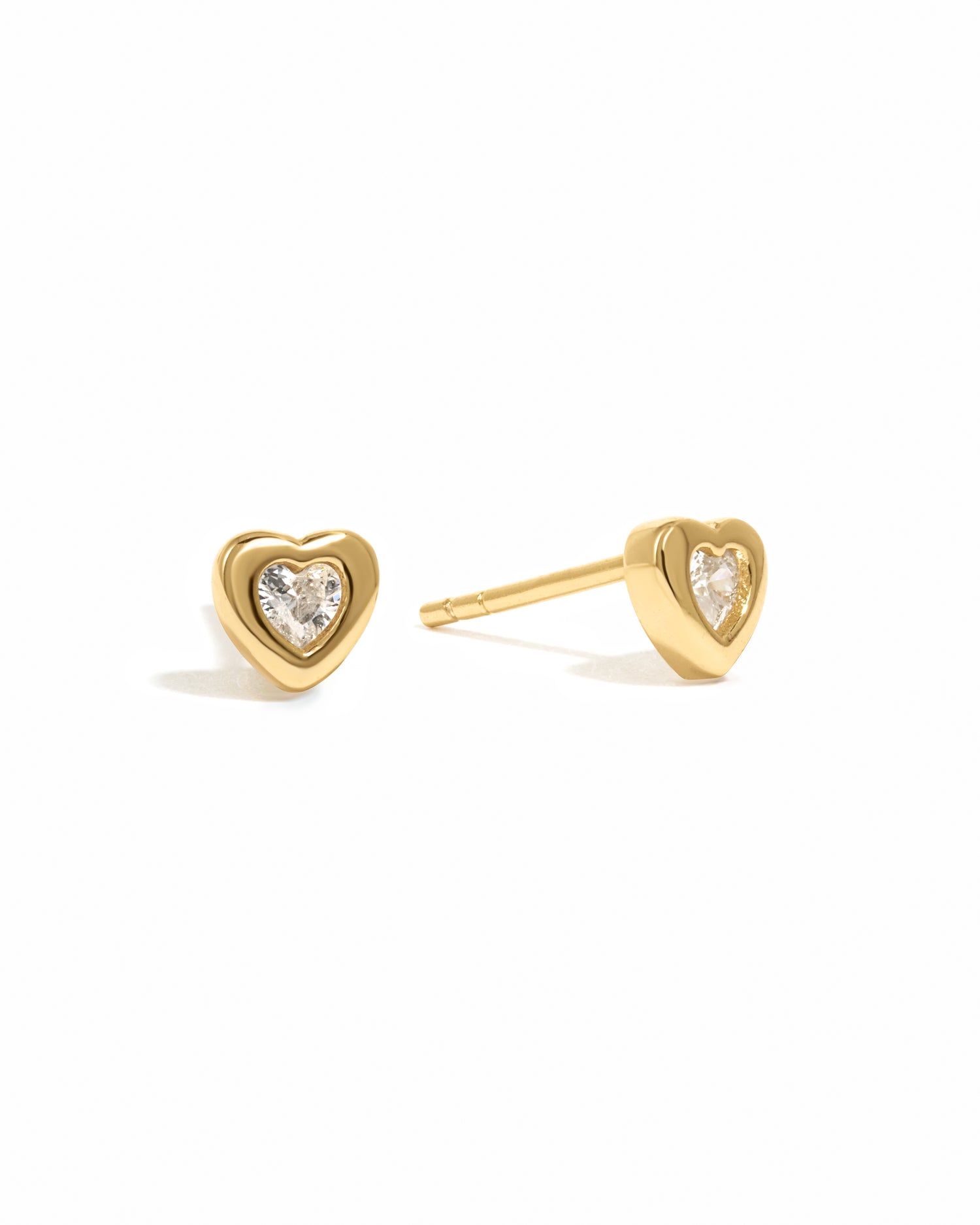 Gold bezel heart stud earrings by Sami Jewels, featuring a delicate heart design on a white background