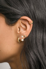 Sami Jewels bezel heart stud earrings featuring gold-tone hearts with a bezel setting, close-up on model's ears.