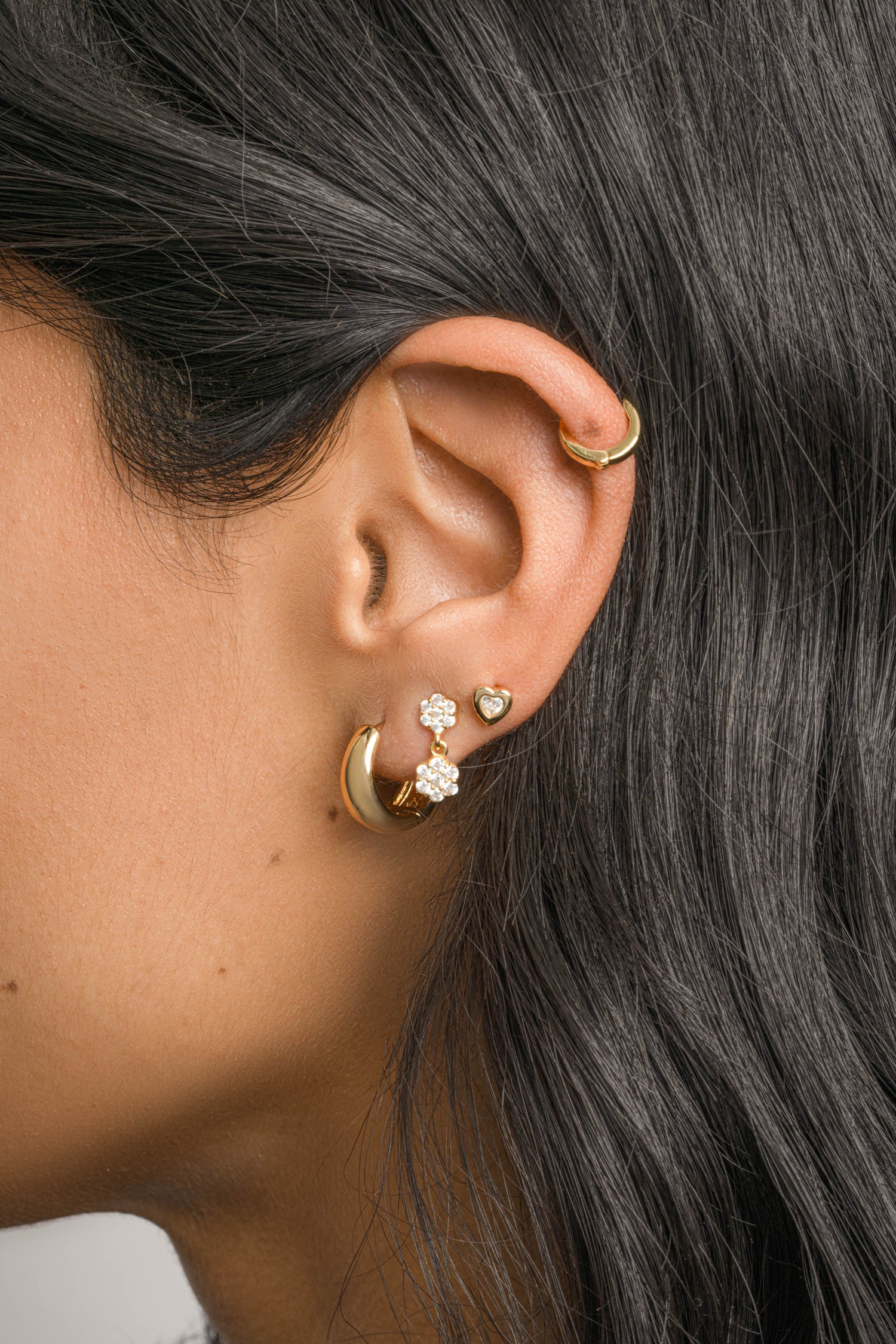 Sami Jewels bezel heart stud earrings featuring small heart-shaped design with a bezel setting, worn by a model.