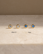 Sami Jewels aquamarine bezel dome stud earrings with white cubic zirconia, showcasing elegant, round gemstone settings.