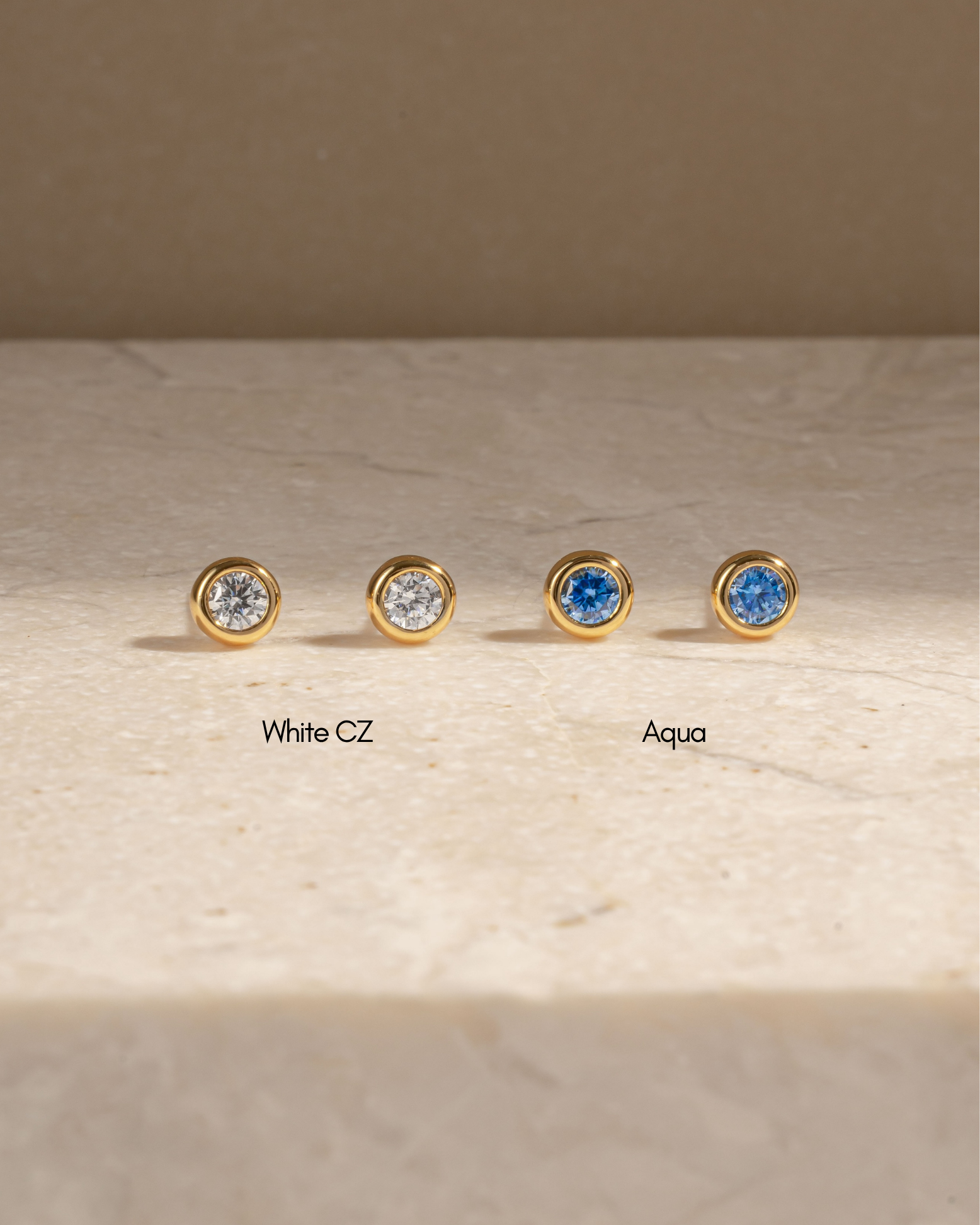 Sami Jewels aquamarine bezel dome stud earrings with white cubic zirconia, showcasing elegant, round gemstone settings.