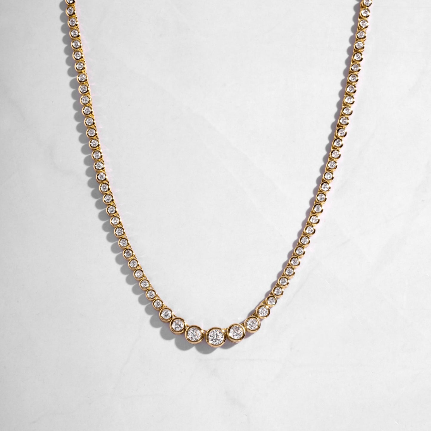 gold necklace set in a diamond tennis chain. 