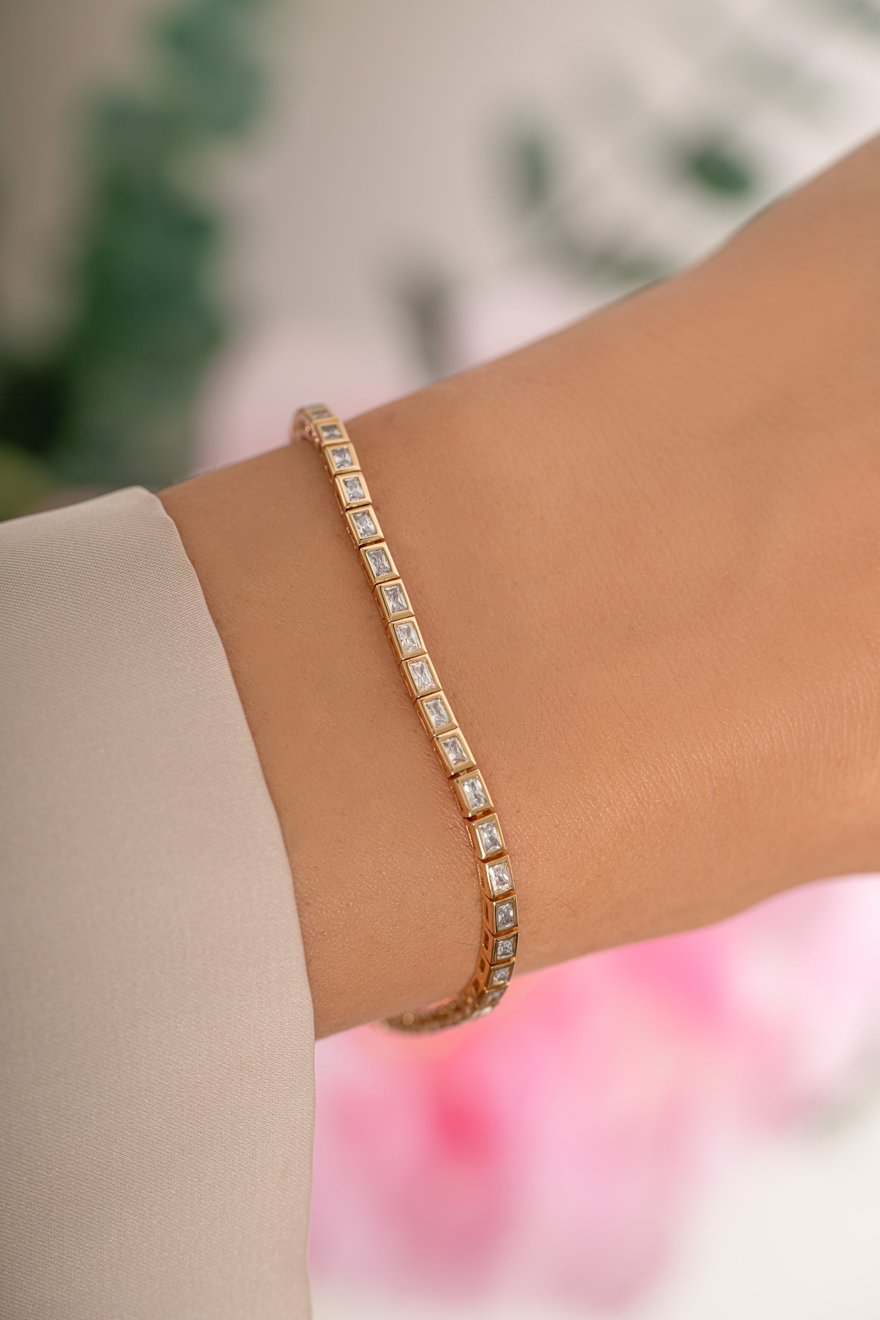 Gold Bezeled Baguette Tennis Bracelet by Sami Jewels featuring sparkling baguette-cut stones on a sleek bracelet.
