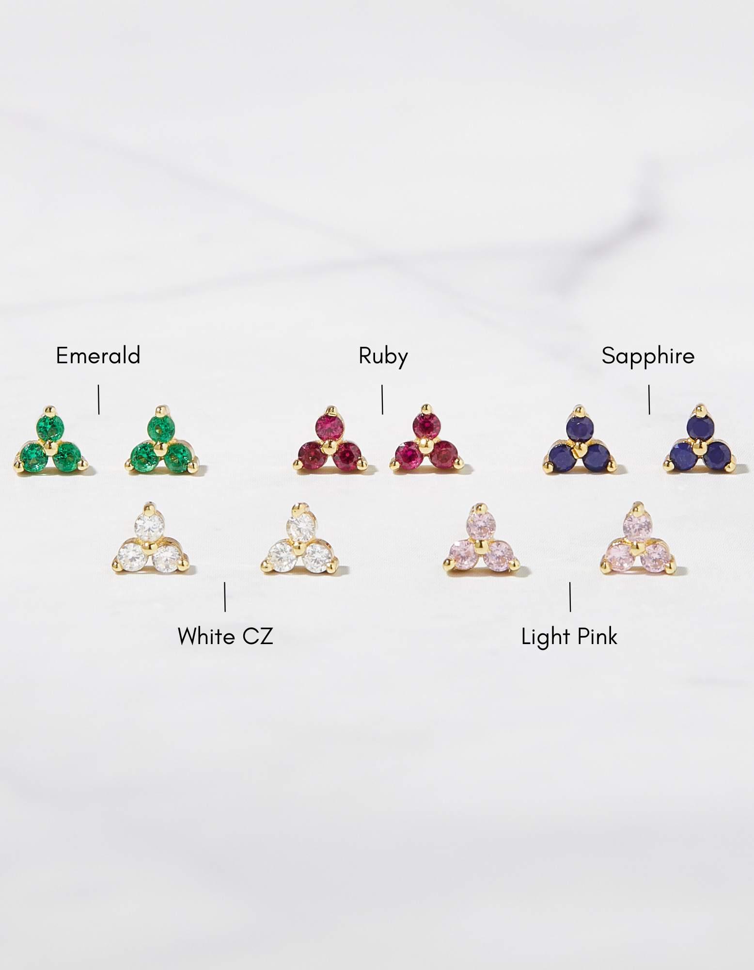birthstone tiny stud earrings in gold showcasing different color variants such as emerald, ruby, sapphire, white cz and light pink