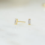 closeup of dainty gold gemstone earrings