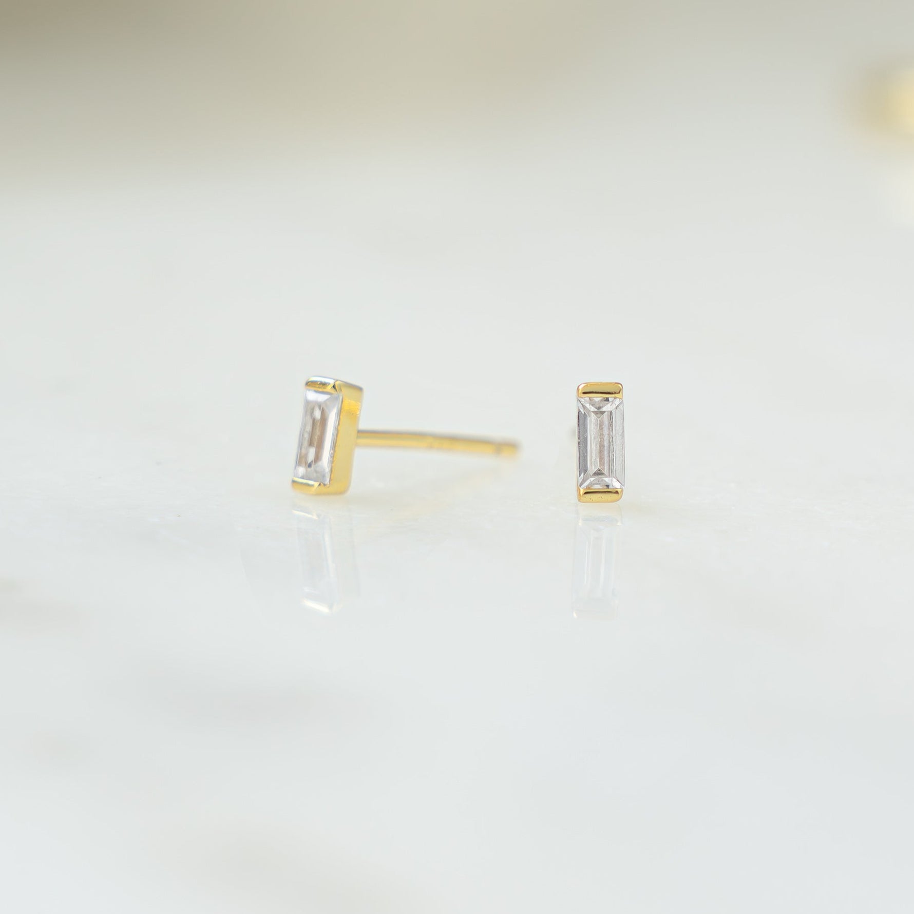 closeup of dainty gold gemstone earrings