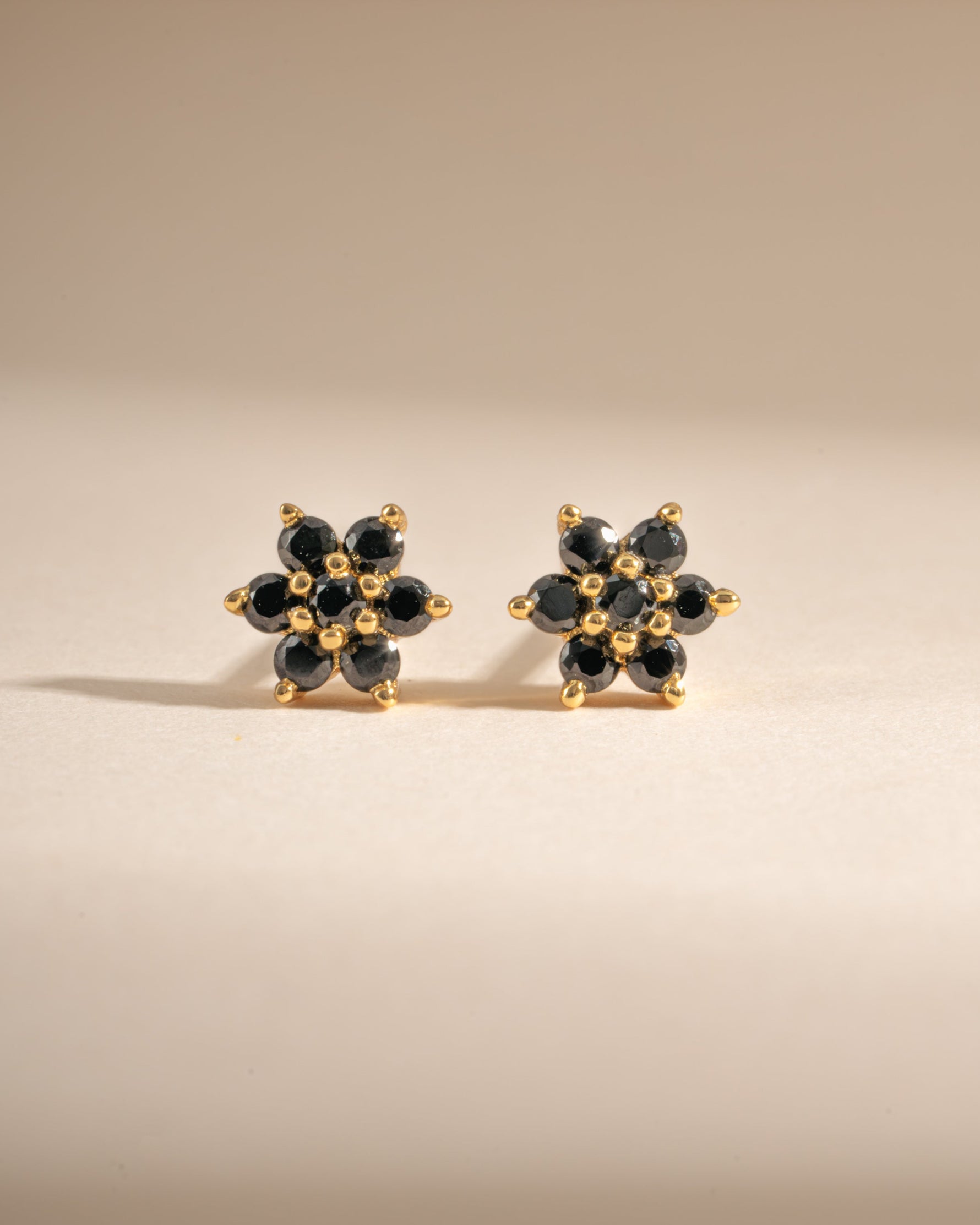 Gold-front view of Sami Jewels black flower stud earrings featuring intricate floral design in black.