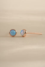 Blue Opal Stud Earrings by Sami Jewels featuring rose gold settings and round blue opal gemstones.