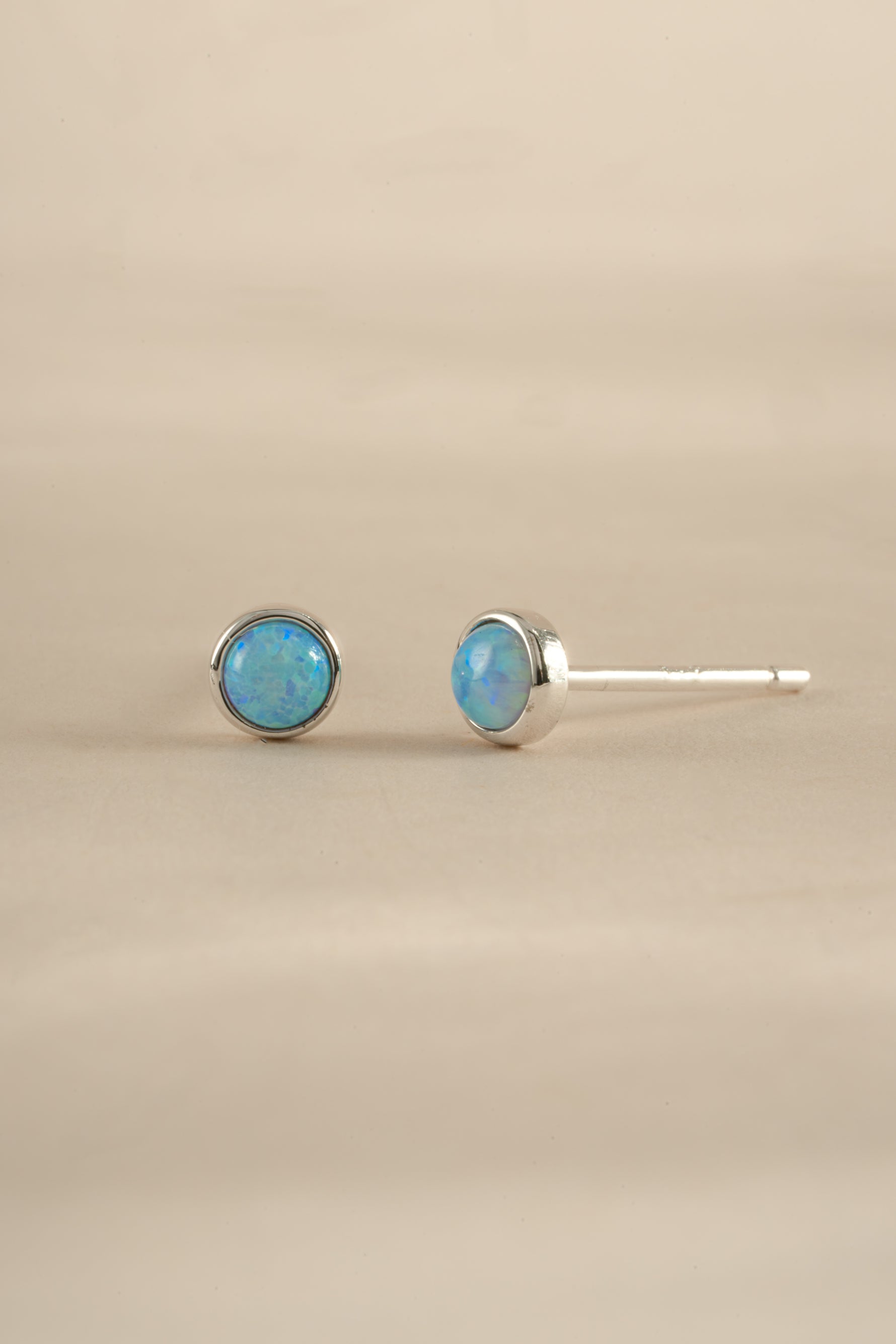 Blue Opal Stud Earrings by Sami Jewels featuring sterling silver settings and vibrant blue opal gemstones.