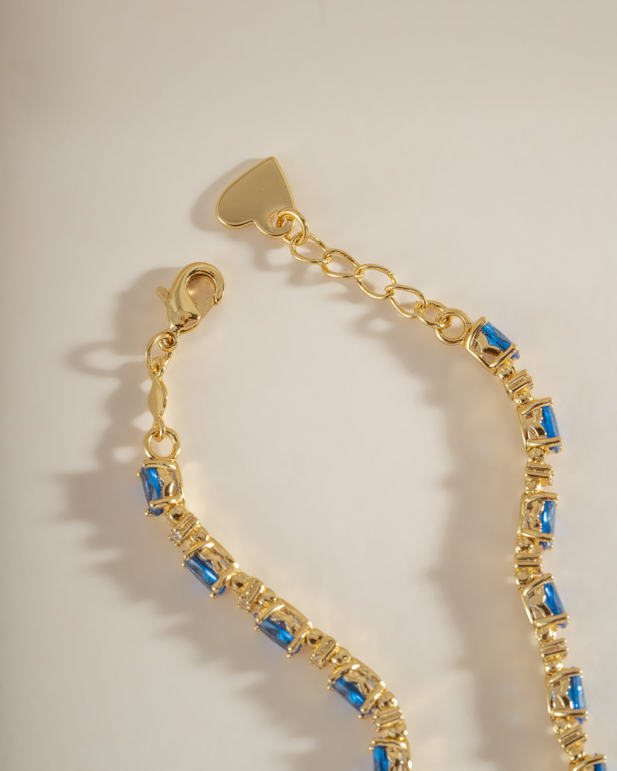 Gold tennis bracelet with oval sapphires and round diamonds with an adjustable clasp.