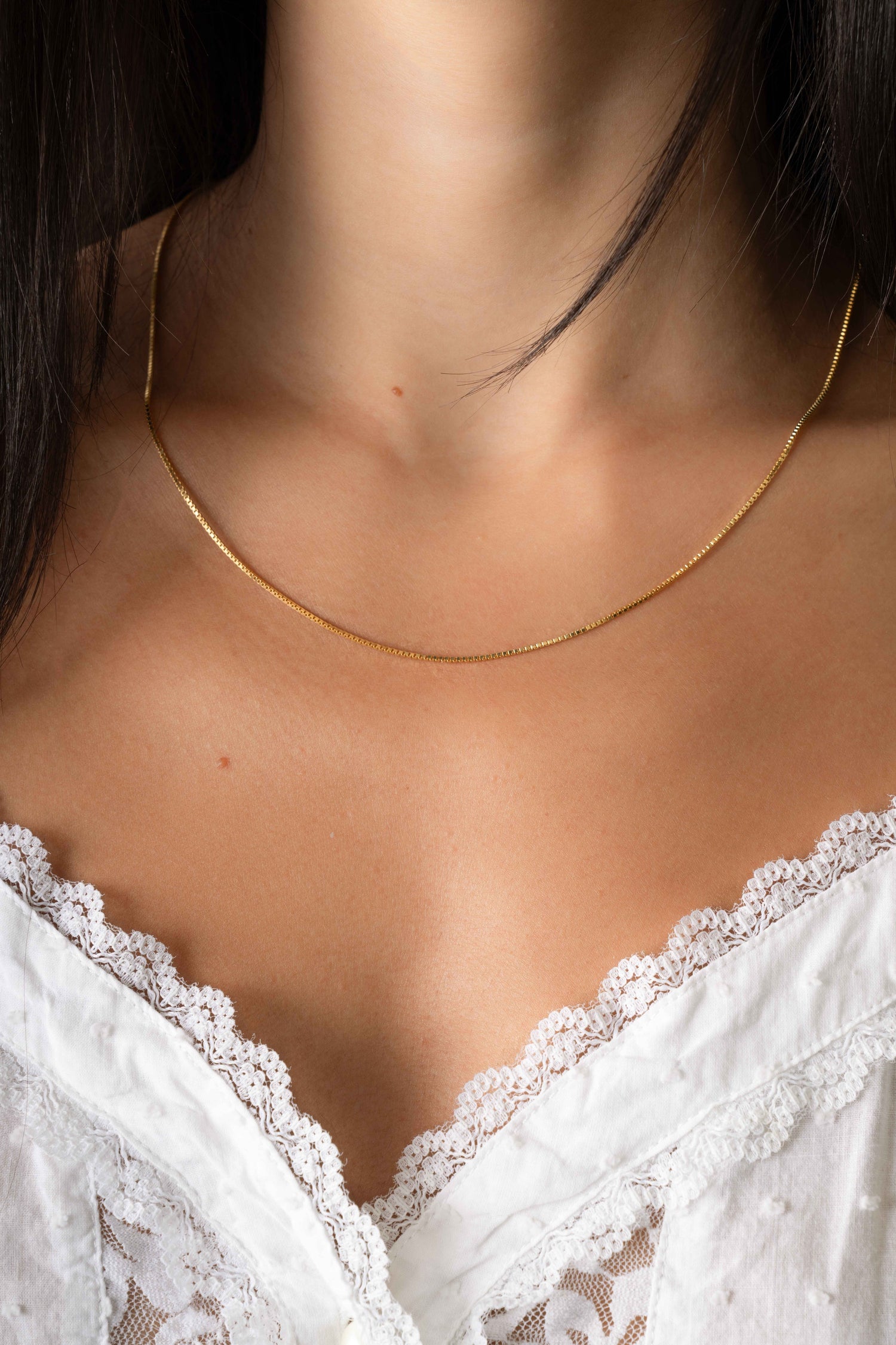 Gold box chain necklace by Sami Jewels, close-up of the elegant, rectangular link design worn by a model.
