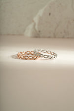 Rose gold and sterling silver braided eternity ring by Sami Jewels, showcasing intricate woven design and polished finish.