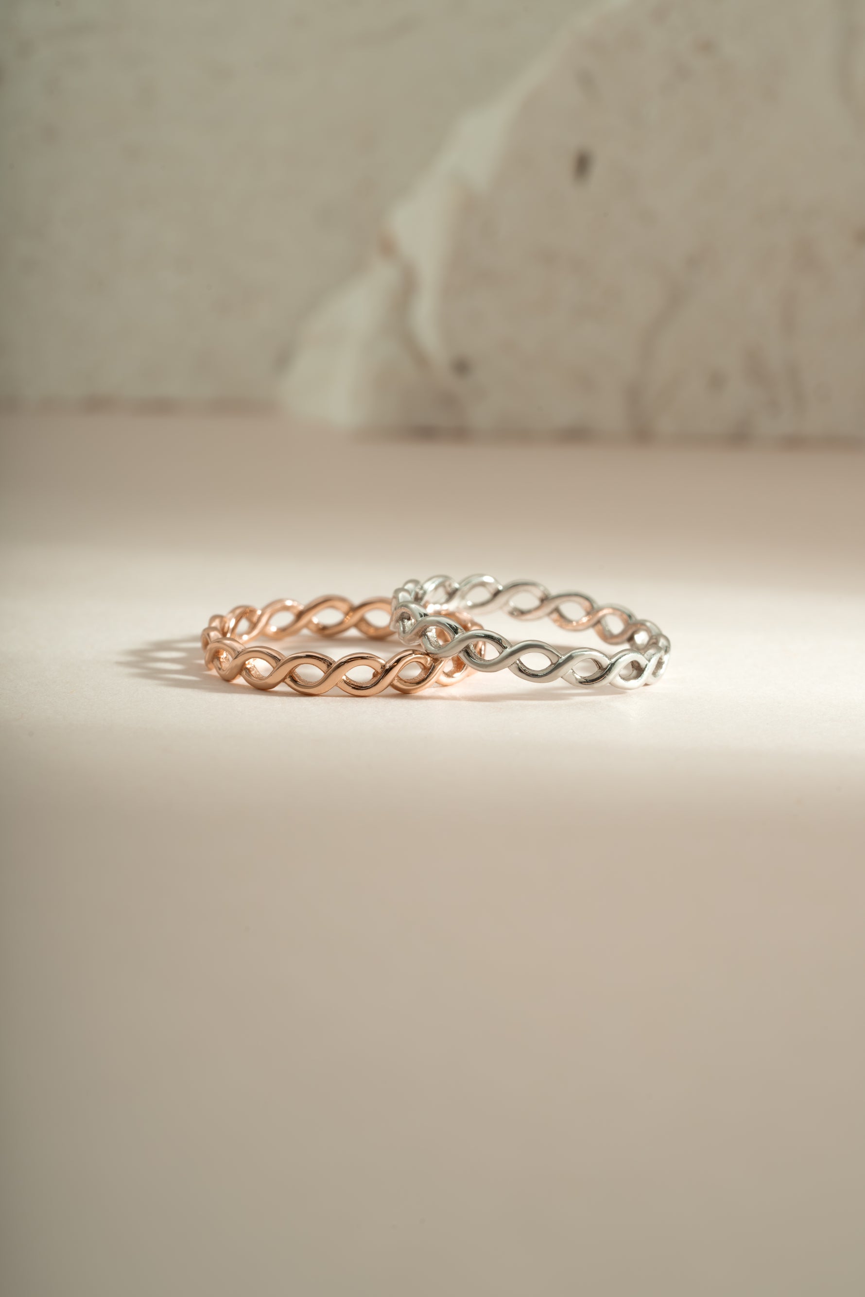 Rose gold and sterling silver braided eternity ring by Sami Jewels, showcasing intricate woven design and polished finish.