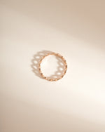 Rose gold braided eternity ring by Sami Jewels, showing a top view of the intricate woven design in a close-up image.