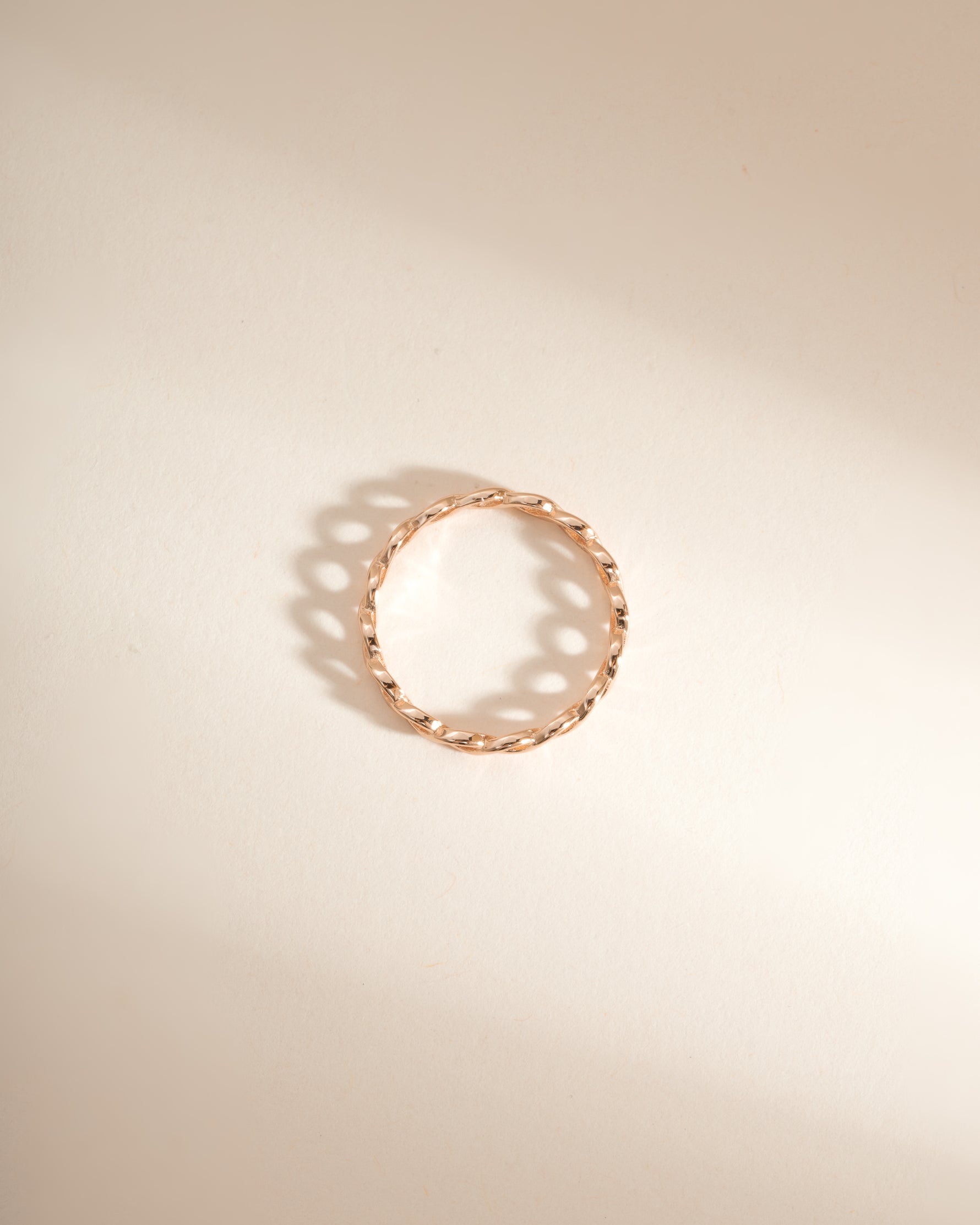 Rose gold braided eternity ring by Sami Jewels, showing a top view of the intricate woven design in a close-up image.