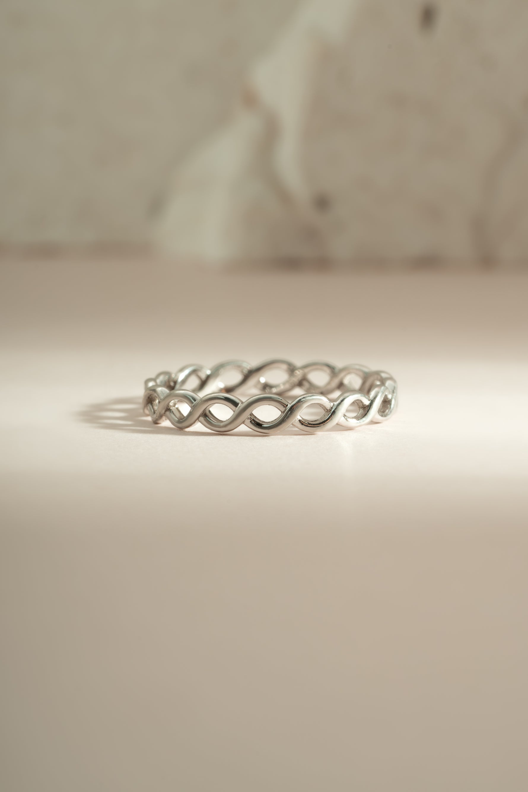 Sterling silver braided eternity ring by Sami Jewels, showcasing a continuous woven design perfect for elegant jewelry.