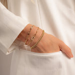 model wearing pave curb chain bracelet, paperclip bracelet, and paperclip charm bracelet