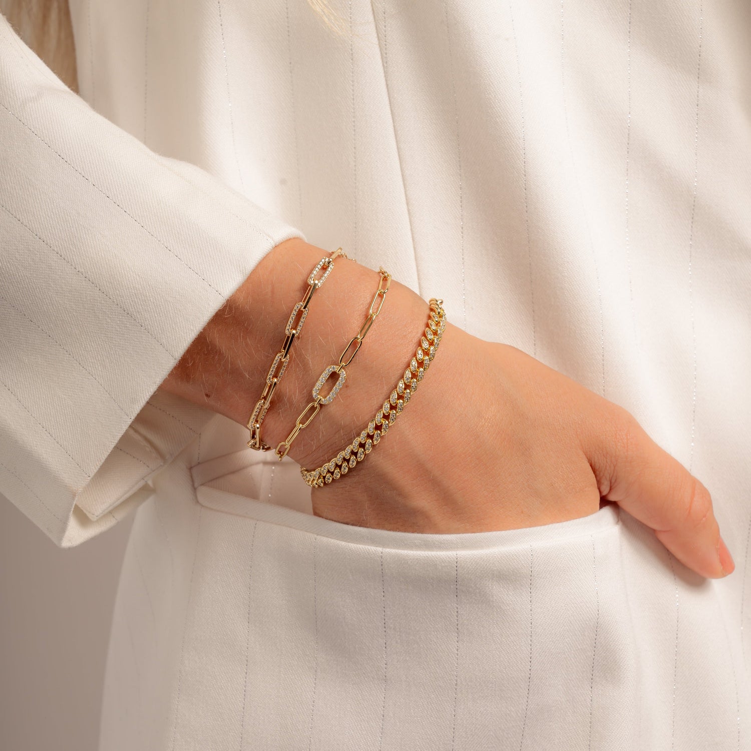 model wearing pave curb chain bracelet, paperclip bracelet, and paperclip charm bracelet