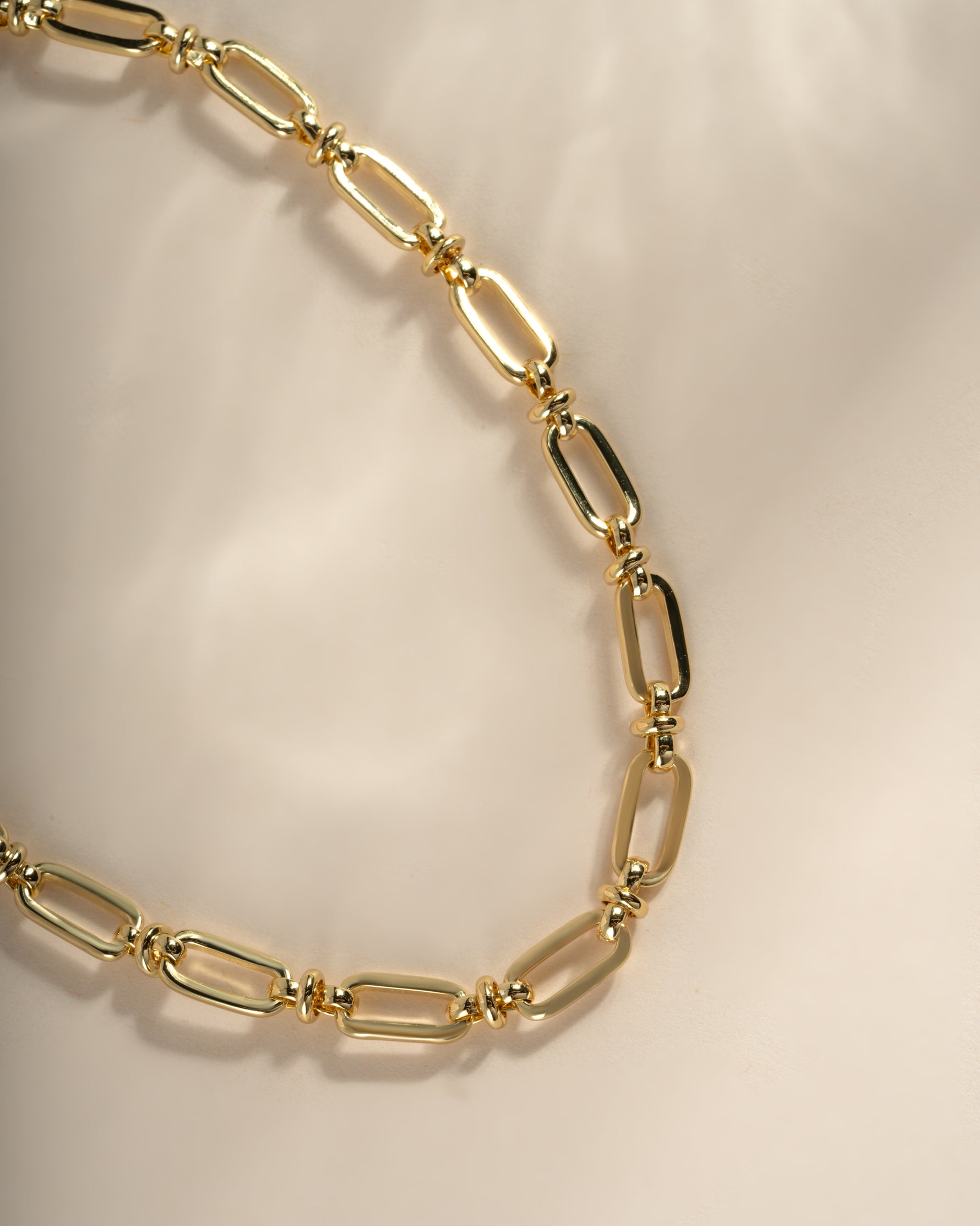 Close-up of a gold chain link necklace from Sami Jewels, showcasing the intricate chain link design.
