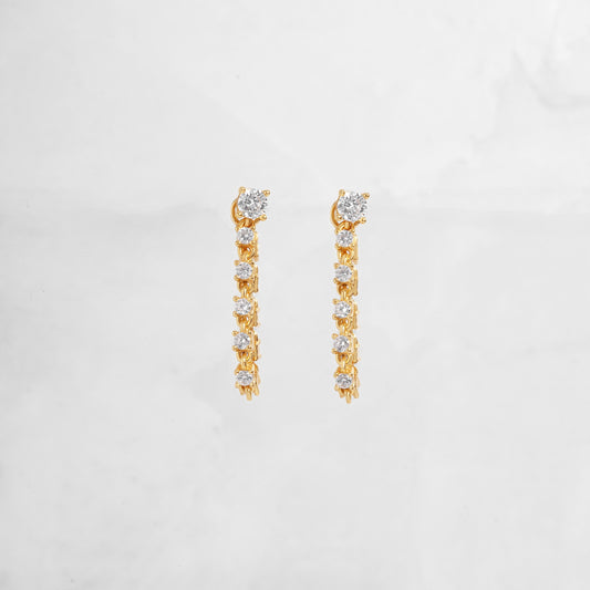 Close-up of gold chain earrings with a smooth, polished texture and delicate hanging links, perfect as gift for her.