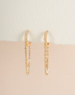 Gold chain link huggie earrings from Sami Jewels, angled view showing their sleek, interconnected design and polished finish.