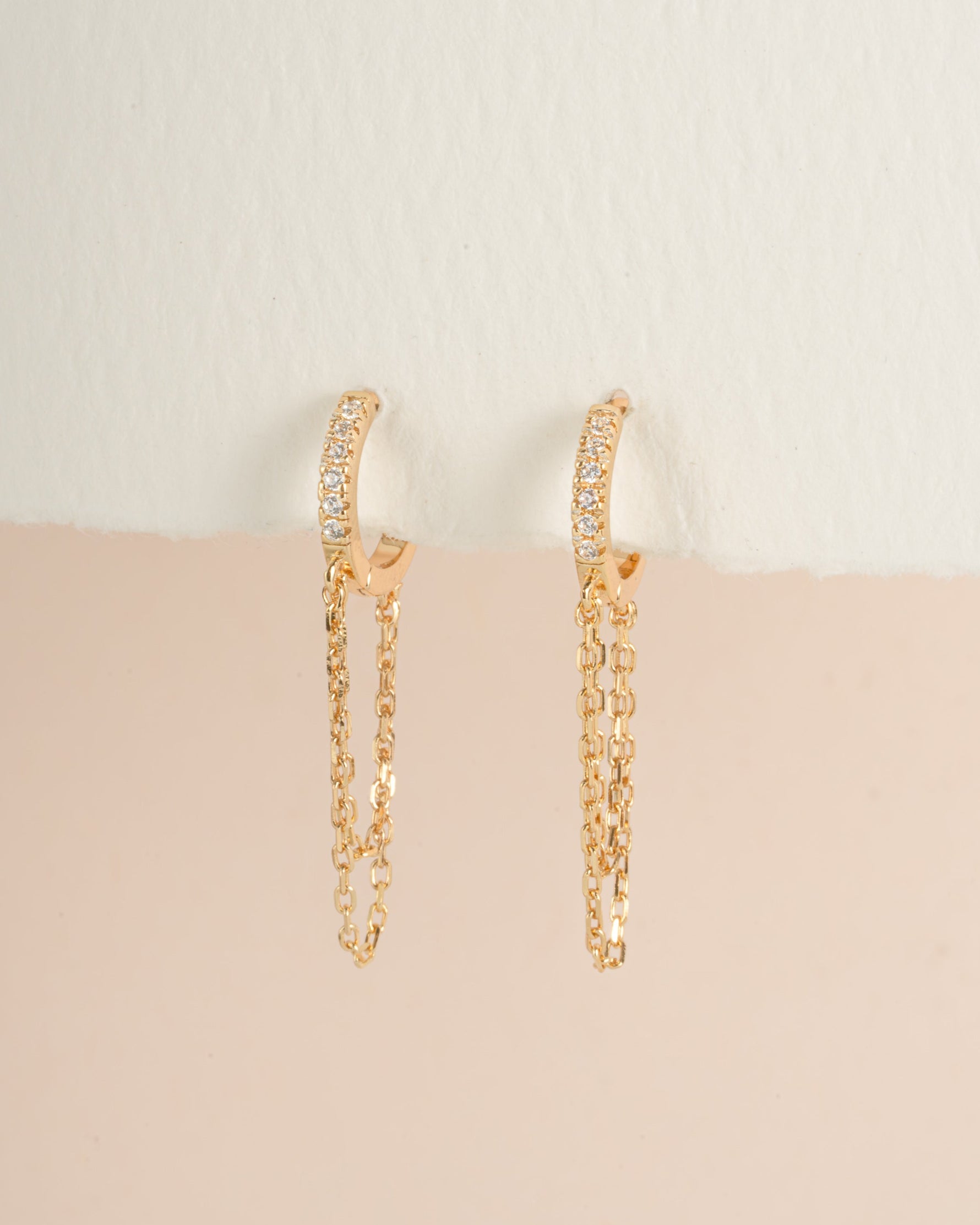 Gold chain link huggie earrings from Sami Jewels, angled view showing their sleek, interconnected design and polished finish.