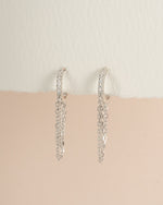 Sterling silver chain link huggie earrings by Sami Jewels, angled view showing the small, interconnected hoop design.