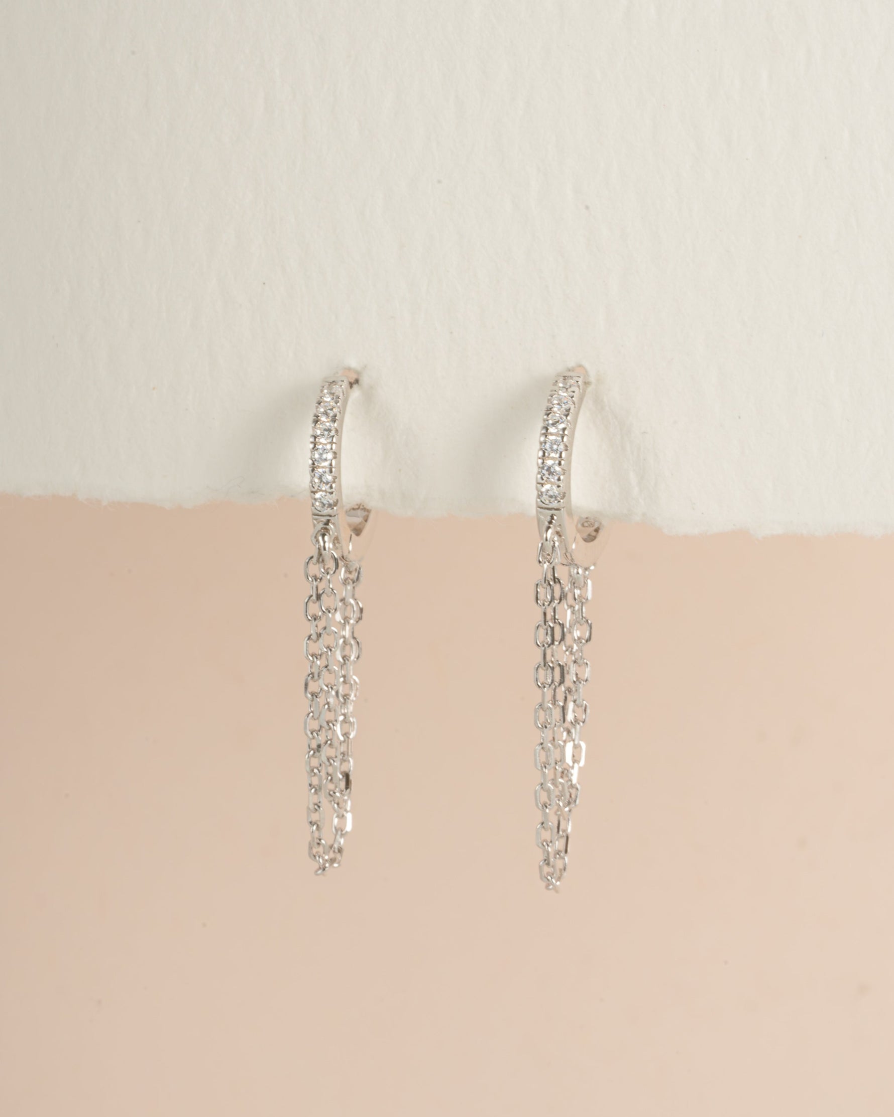 Sterling silver chain link huggie earrings by Sami Jewels, angled view showing the small, interconnected hoop design.