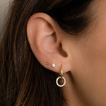 Model wearing Round Pavé Charm Hoops with other dainty gold jewelry for a trendy, stacked look.