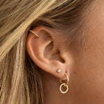 model wearing Circle Charm Hoops stacked with diamond stud earrings and dainty hoop earrings, creating a chic layered earring look.