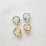 flat lay of lightweight gold and sterling silver hoops with a textured pavé circle charm, adding a subtle touch of sparkle.