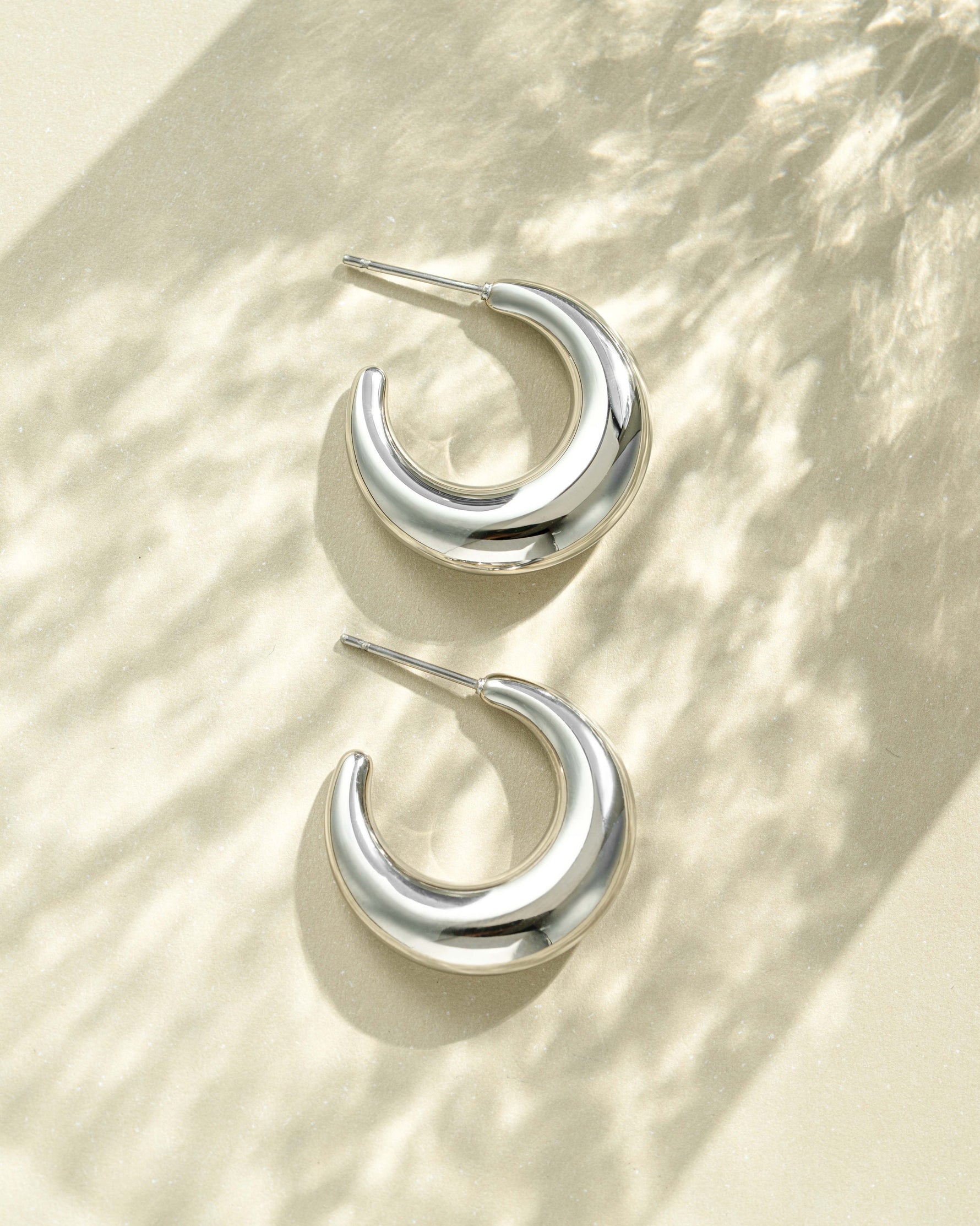 Close-up of SS Gradient Hoops earrings by Sami Jewels, chunky silver crescent hoop earrings made of stainless steel.