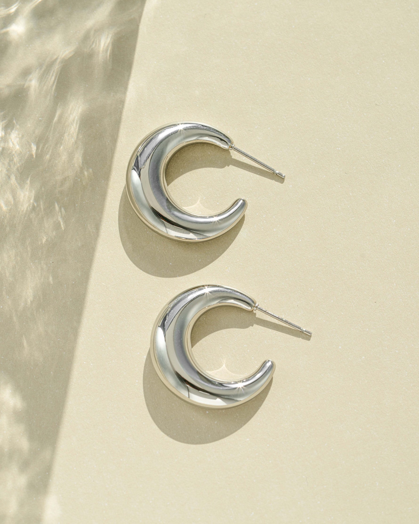 Close-up of silver stainless steel SS Gradient Hoops earrings featuring chunky crescent design by Sami Jewels.