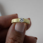 close up of 14k gold ring with its grooved textured surface, that invites the fingertips to explore its raised, rhythmic design.