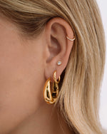 Stack of chunky stainless steel gold hoop earrings from Sami Jewels, showcasing their waterproof and stylish design.