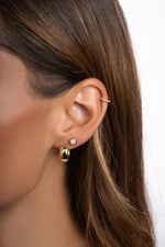Gold small chunky hoop earrings by Sami Jewels worn by a model, close-up view showing their bold, stylish design.
