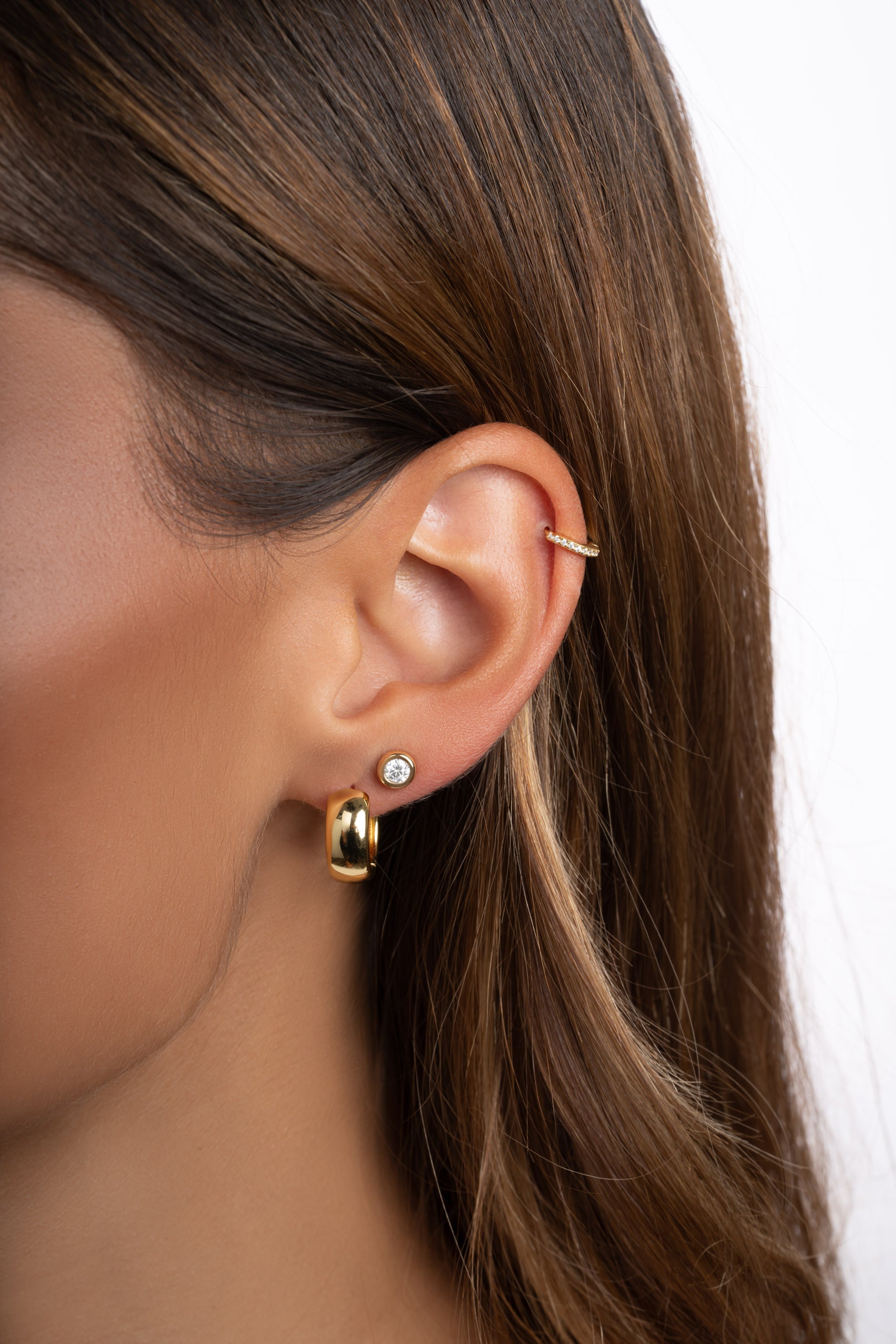 Gold small chunky hoop earrings by Sami Jewels worn by a model, close-up view showing their bold, stylish design.