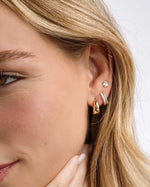 Gold 15mm chunky huggie hoop earrings worn by a model, featuring a bold, rounded design by Sami Jewels.