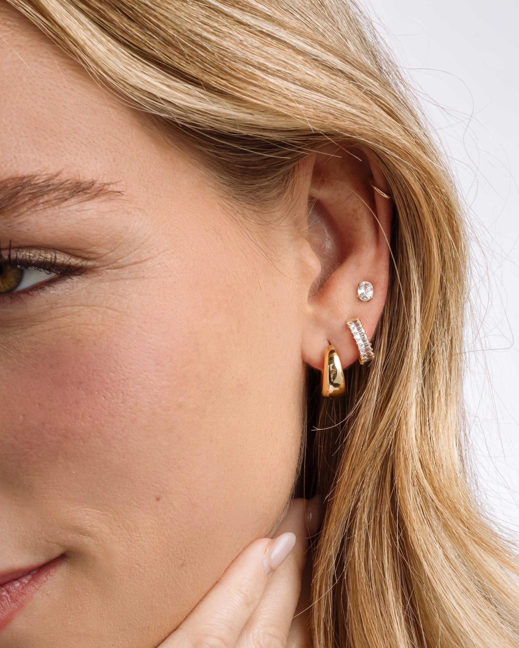 Gold 15mm chunky huggie hoop earrings worn by a model, featuring a bold, rounded design by Sami Jewels.