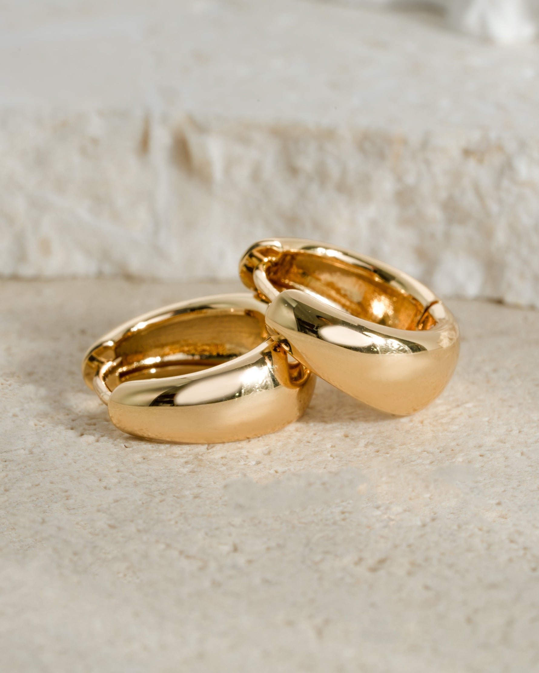 Close-up of gold 15mm chunky huggie hoops earrings by Sami Jewels showing their bold, rounded design and polished finish.