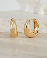 Close-up of gold 15mm chunky huggie hoops earrings by Sami Jewels showing their bold, rounded design and polished finish.