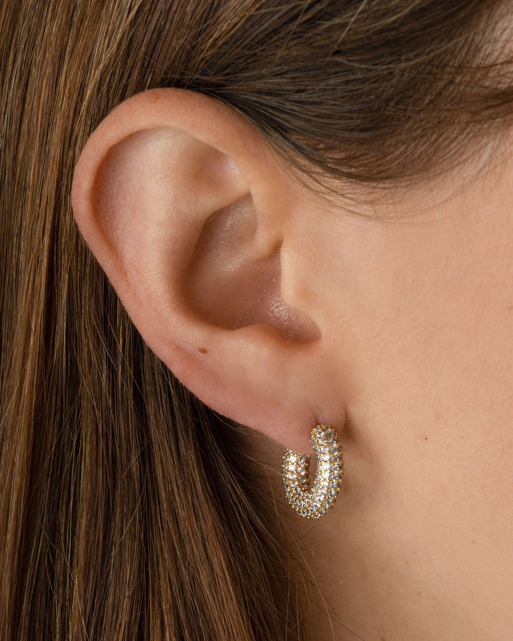 Gold Sami Jewels chunky pavé hoop earrings with sparkling pave design worn by a model.