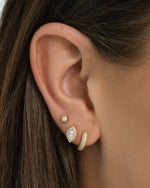 Gold Sami Jewels Chunky Pavé Huggie Earrings featuring bold, sparkling pave design on a model.