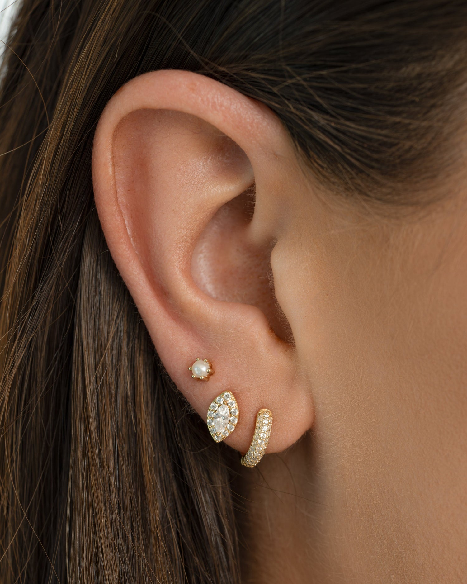 Gold Sami Jewels Chunky Pavé Huggie Earrings featuring bold, sparkling pave design on a model.