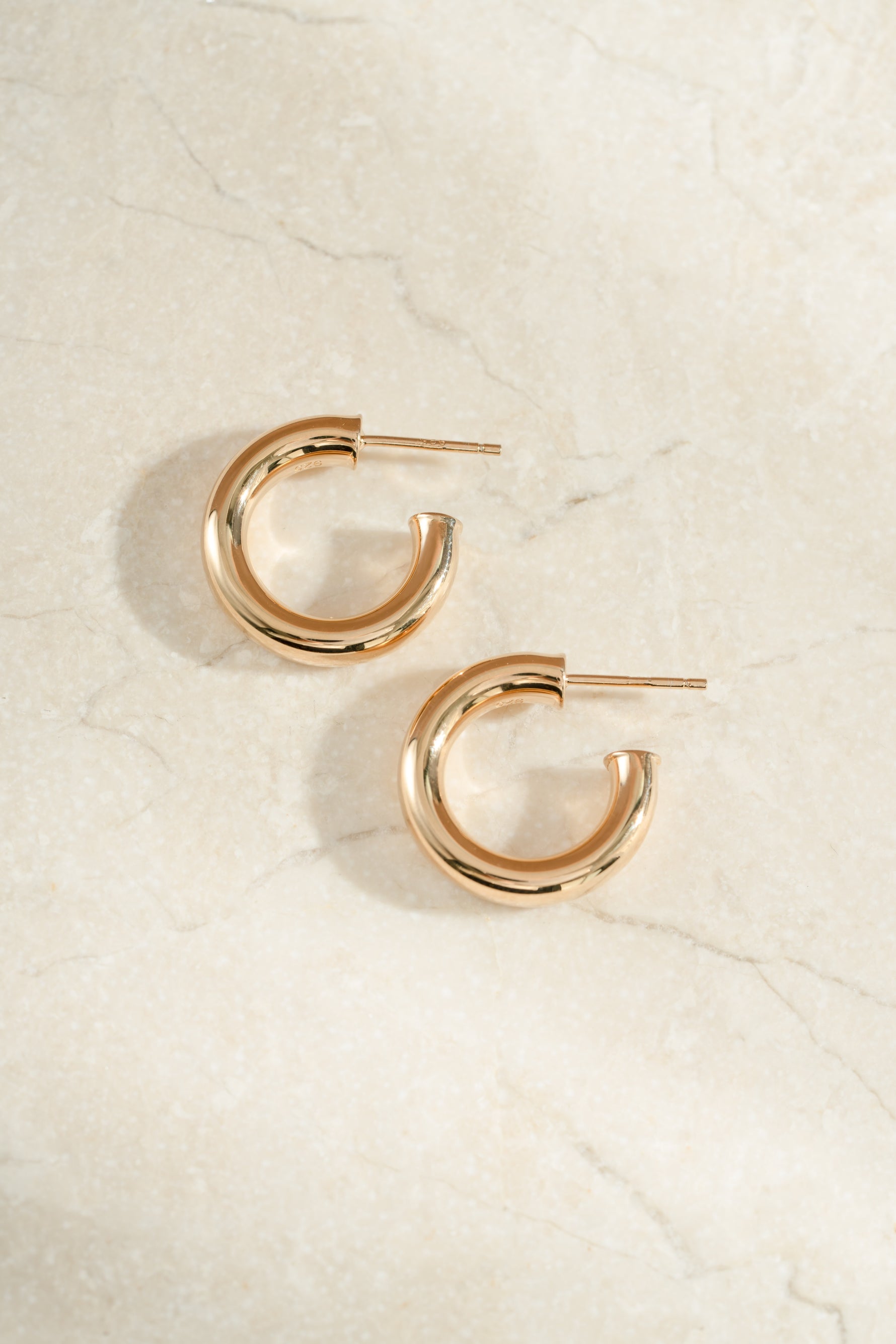 chunky tube hoop earrings in 24mm in gold side view 