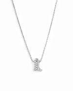 A silver-toned necklace featuring a small boot-shaped pendant paved with clear stones, displayed against a clean white background.