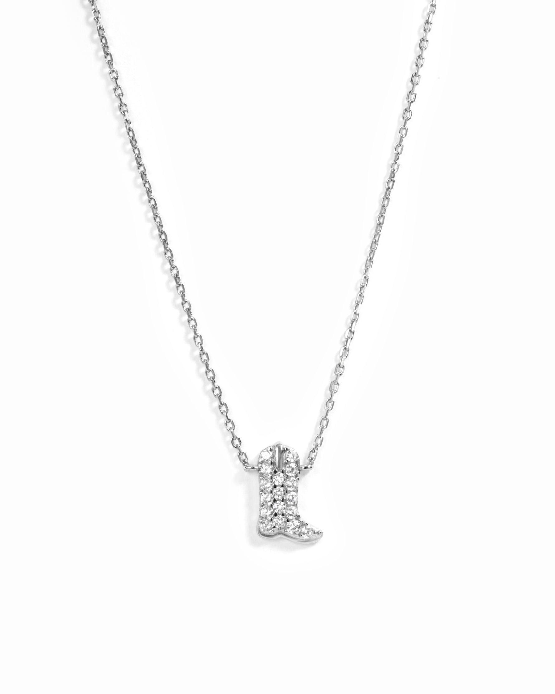 A silver-toned necklace featuring a small boot-shaped pendant paved with clear stones, displayed against a clean white background.