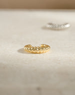 Close-up of a gold croissant ear cuff earring by Samijewels-527, showcasing its unique curved design and texture.