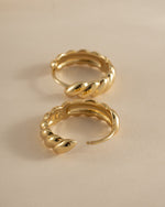 Gold croissant hoop earrings by Sami Jewels, showcasing stylish jewelry with a shiny, curved hoop design.